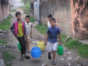 Some of the older boys carrying water to the Home